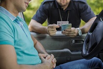 Police officer looking at person's ID. 